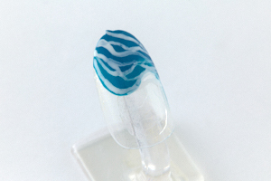 乾いたら、「おそら」と「水浅黄」の上に、つまようじを使って「胡粉」で波のようなラインを描く。フリーハンドで優雅に描くのがポイント