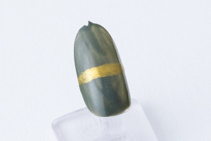 爪の真ん中につまようじの頭で、「黄金色」を使って横線を描きます。一度塗りで薄い場合、上から塗り重ねます。