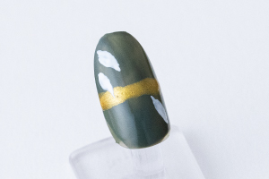 薬指と小指の爪につまようじの先で、「胡粉」を使って葉っぱを描きます。一度塗りで薄い場合、上から塗り重ねます。すべての爪に「スーパーコート」を塗って完成です。