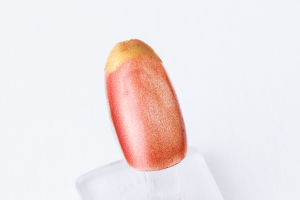 人差し指、小指に「緋銅色」を三度重ね塗りして乾かし、爪先に「黄金色」でフレンチネイルを描きます。