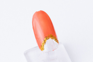 金粉を「スーパーコート」に馴染ませ、爪楊枝で境目を丸く囲み、親指はその上にもカーブを意識した線を引きます。