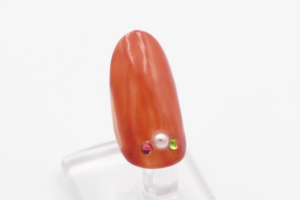 人差し指、薬指、小指に「一斤染」を三度塗りして、お好みのストーンやパーツで飾ります。「スーパーコート」を糊代わりに使用するとしっかりくっつきます。